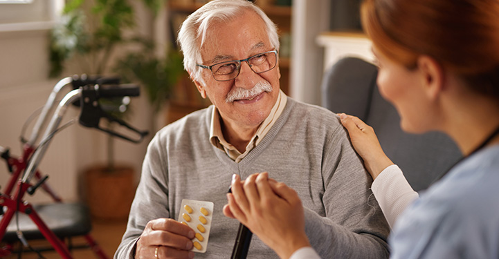 a young woman delivering groceries to an elderly woman in a hallway smiling and interacting gracefully community service support food delivery assistance