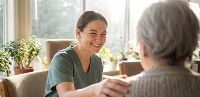smiling caregiver interacting with elderly person in a bright comfortable setting two people connecting in care